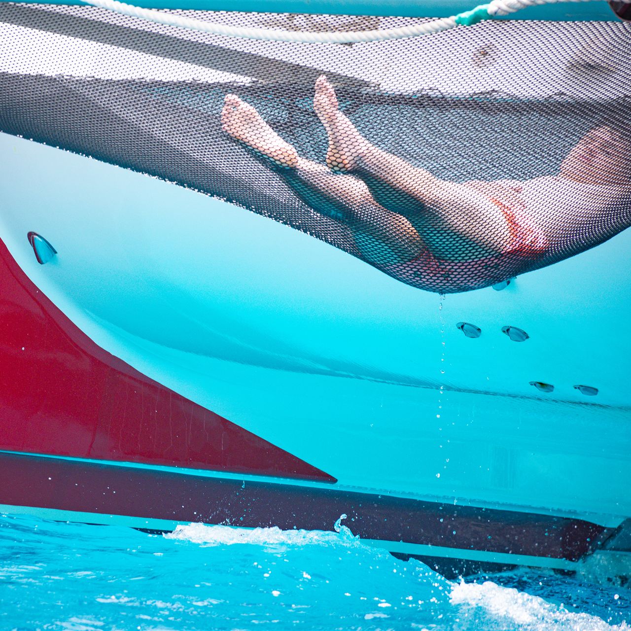 Relax en la red del catamaran sobre el mar turquesa
